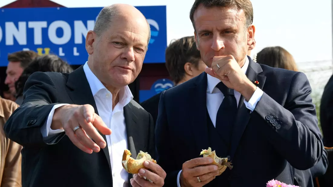 Bundeskanzler Olaf Scholz (SPD) und Frankreichs Präsident Emmanuel Macron (r) essen an der Elbe in Hamburg-Blankenese Fischbrötchen. - Bild: Fabian Bimmer/Reuters/Pool/dpa