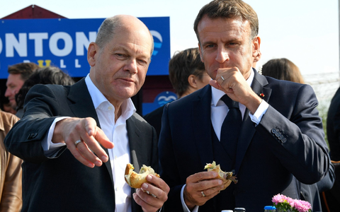 Bundeskanzler Olaf Scholz (SPD) und Frankreichs Präsident Emmanuel Macron (r) essen an der Elbe in Hamburg-Blankenese Fischbrötchen. - Foto: Fabian Bimmer/Reuters/Pool/dpa