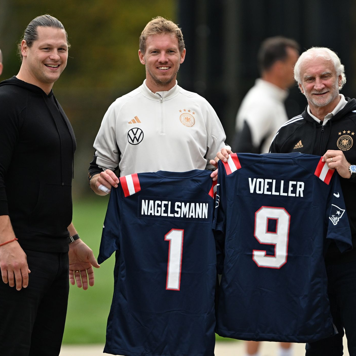 Julian Nagelsmann und Rudi Völler mit Trikots der New England Patriots. - Foto: Federico Gambarini/dpa