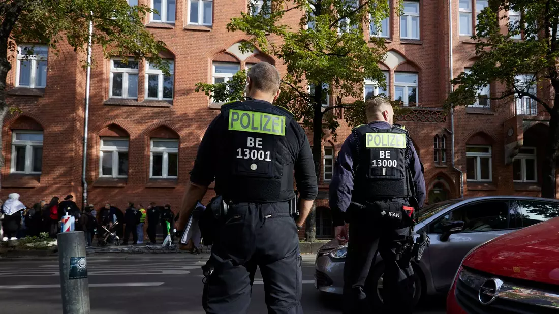 Polizisten stehen vor der Schule in Berlin-Neukölln. - Bild: Joerg Carstensen/dpa