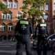 Polizisten stehen vor der Schule in Berlin-Neukölln. - Foto: Joerg Carstensen/dpa
