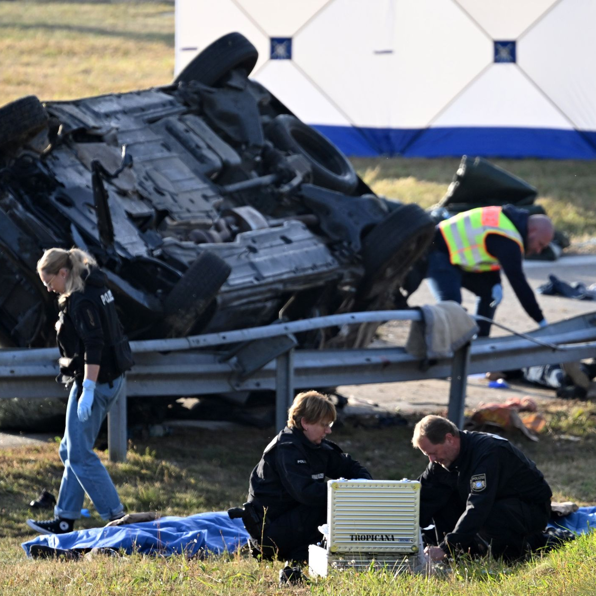Rettungskräfte und Polizisten am umgestürzten Fahrzeug. Beim Unfall sind sieben Menschen gestorben und mehrere schwer verletzt worden. - Foto: Sven Hoppe/dpa
