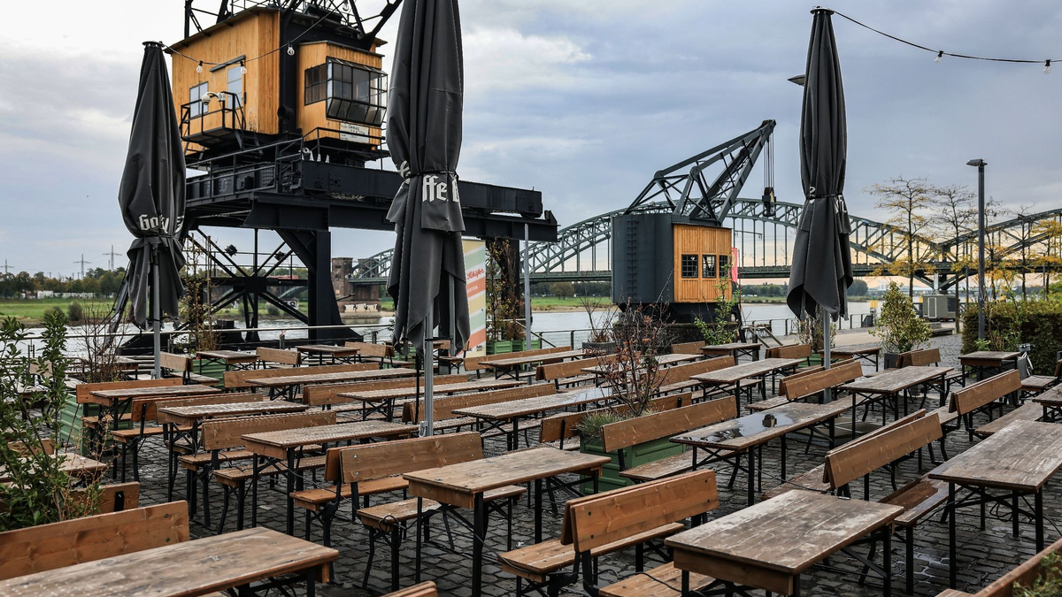 Leere Tische und Bänke am Rheinauhafen in Köln. - Foto: Oliver Berg/dpa