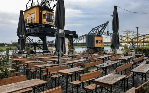 Leere Tische und Bänke am Rheinauhafen in Köln. - Foto: Oliver Berg/dpa