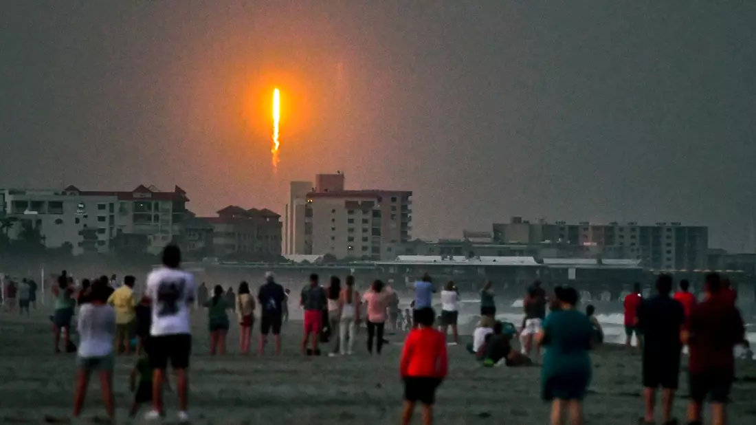 Menschen beobachten am Cocoa Beach im US-Bundesstaat Florida, wie die SpaceX-Rakete in Cape Canaveral abhebt. - Bild: Malcolm Denemark/Florida Today/AP/dpa