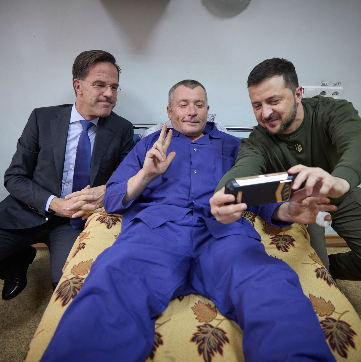 Ein verwundeter ukrainischer Soldat macht ein Selfie mit Präsident Wolodymyr Selenskyj und dem niederländischen Regierungschef Mark Rutte, der zu Besuch in der stark von russischen Luftangriffen betroffenen Hafenstadt Odessa ist. - Foto: Uncredited/Ukrainian Presidential Press Office/AP