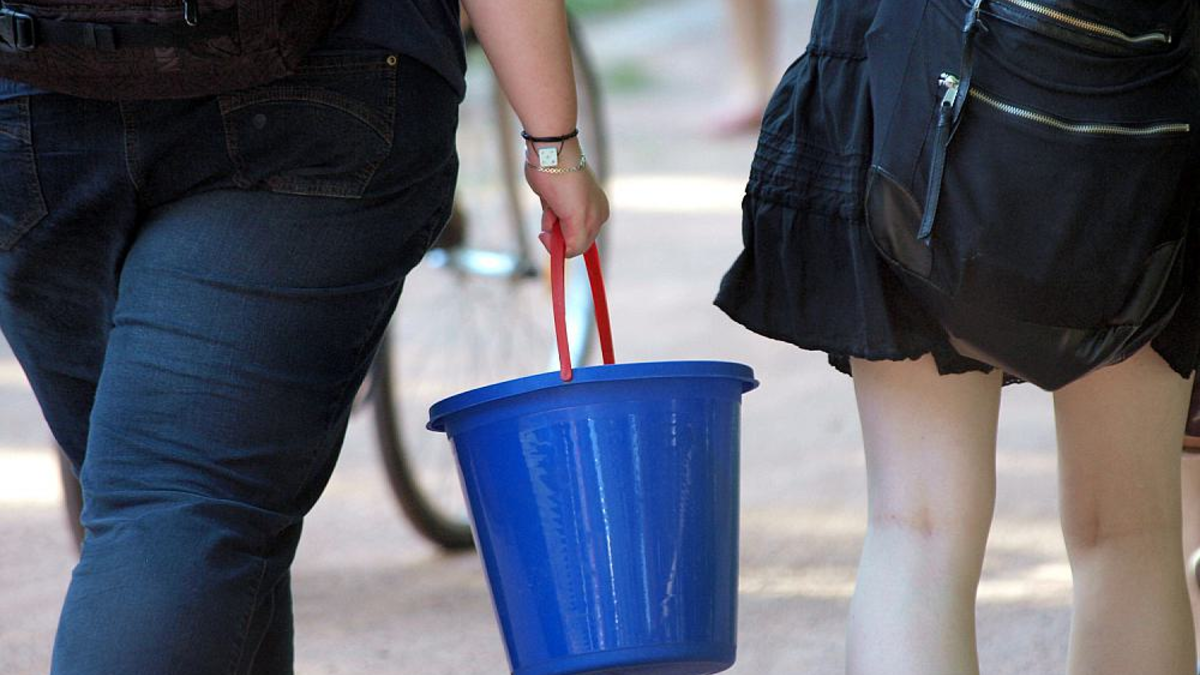 Zwei Frauen tragen einen Wassereimer (Archiv) - Foto: über dts Nachrichtenagentur