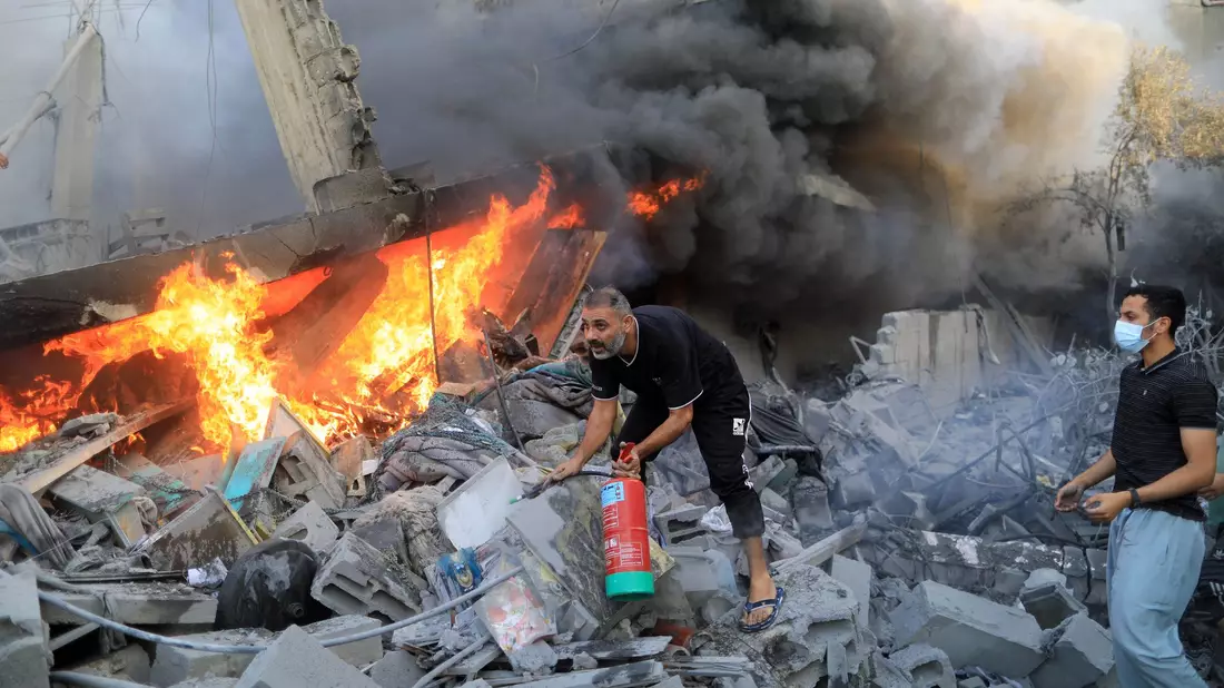 Nach einem israelischen Luftangriff in der Stadt Khan Yunes im südlichen Gazastreifen löschen Menschen das Feuer in den Trümmern. - Bild: Yasser Qudih/XinHua/dpa