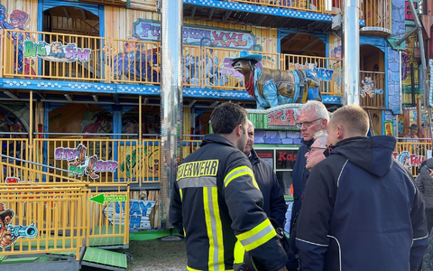 Feuerwehrleute und Polizisten stehen vor dem Funhouse auf dem Pollhansmarkt in Schloß Holte-Stukenbrock. - Foto: Christian Müller/Westfalennews/dpa