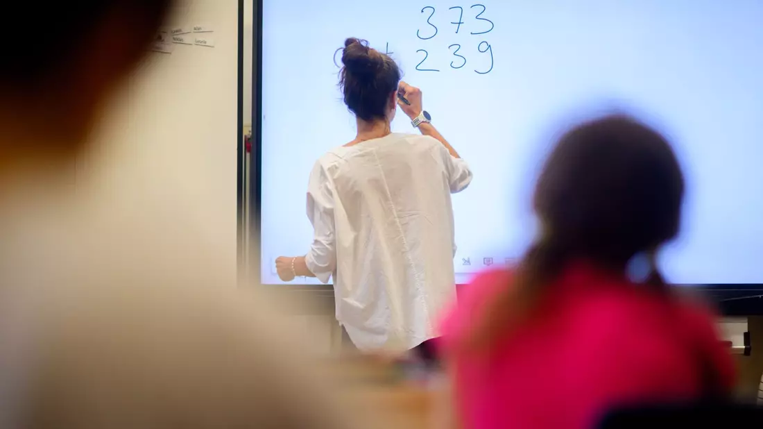 Eine Lehrerin schreibt eine Mathematikaufgabe auf eine digitale Schultafel im Klassenraum einer 4. Klasse einer Grundschule. - Bild: Julian Stratenschulte/dpa
