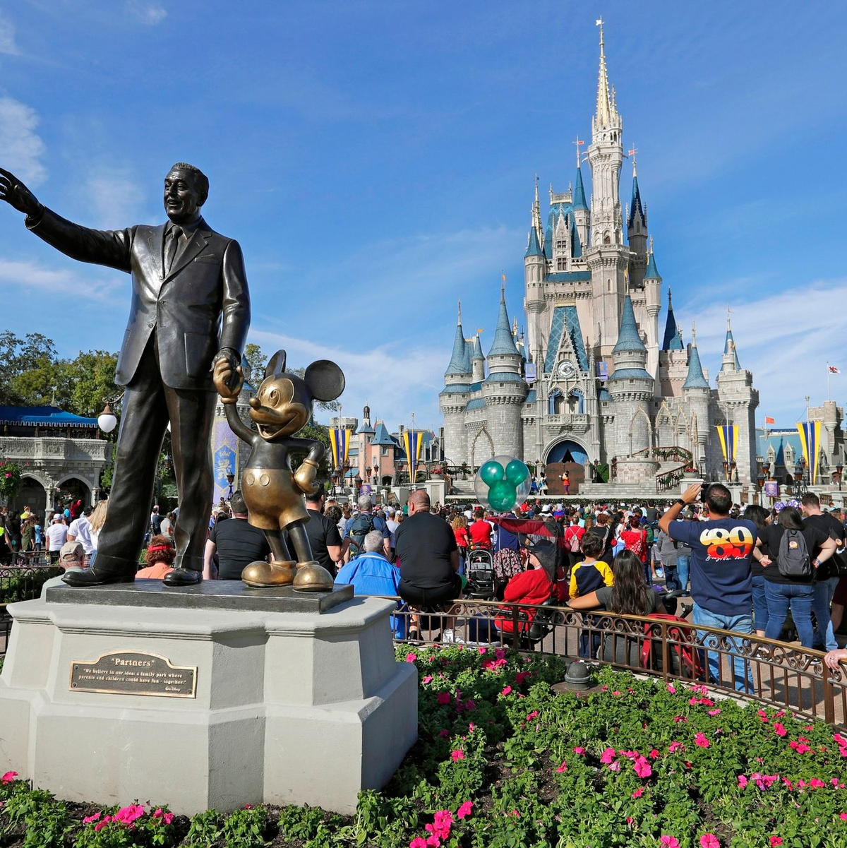 Eine Statue von Walt Disney und Micky Maus  vor dem Cinderella-Schloss im Magic Kingdom von Walt Disney World in Florida. - Foto: John Raoux/AP/dpa
