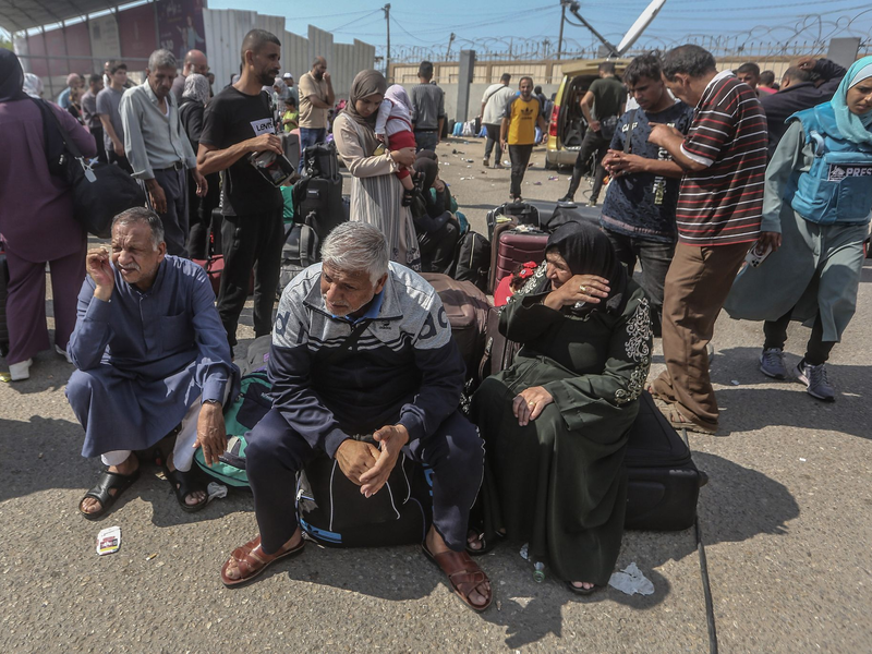 Palästinenser, einige mit ausländischen Pässen, warten am Grenzübergang Rafah auf Hilfe und eine mögliche Einreise nach Ägypten. - Foto: Mohammed Talatene/dpa