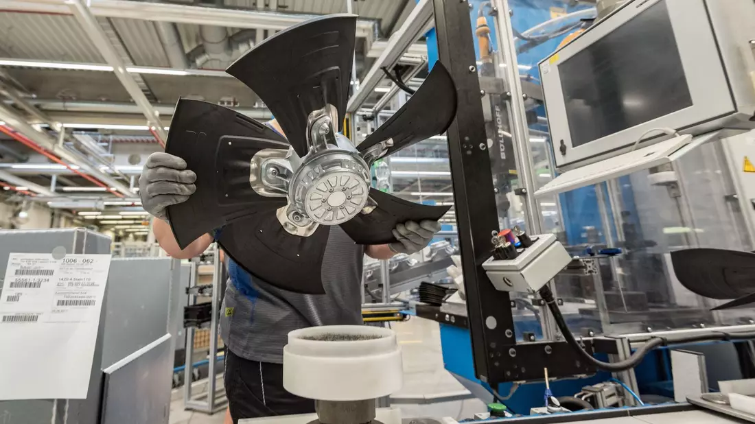 Ein Mitarbeiter eines Herstellers von Ventilatoren und Elektromotoren montiert einen Lüfter. - Bild: picture alliance / Daniel Maurer/dpa