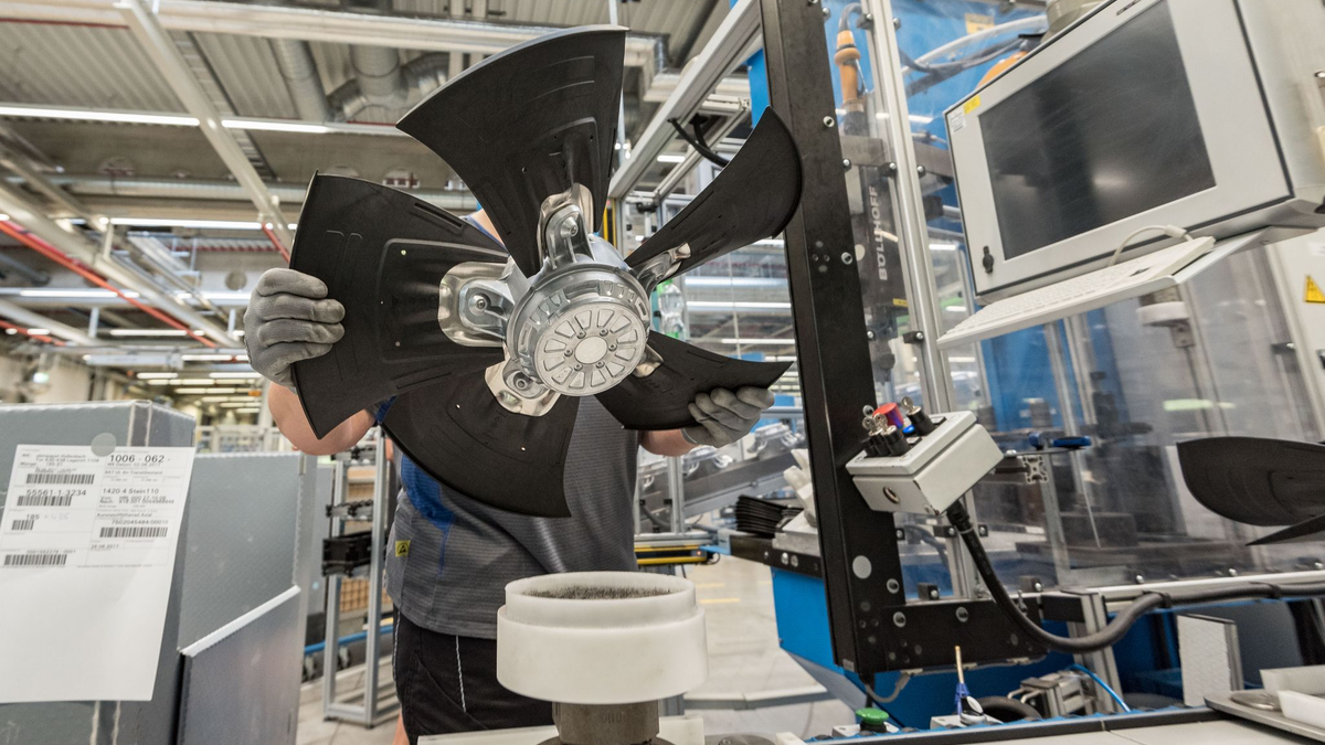 Ein Mitarbeiter eines Herstellers von Ventilatoren und Elektromotoren montiert einen Lüfter. - Foto: picture alliance / Daniel Maurer/dpa
