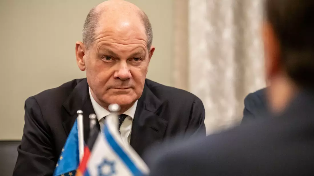 Bodyguards bringen Bundeskanzler Olaf Scholz (SPD, M) nach einem Luftalarm am Ende seines Solidaritätsbesuches in Israel in sein Flugzeug. - Bild: Michael Kappeler/dpa Pool/dpa