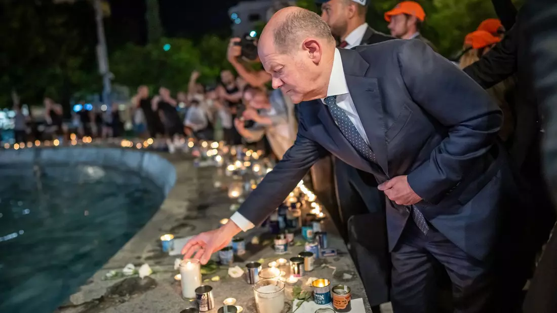 Bundeskanzler Olaf Scholz (SPD) steht bei seinem Solidaritätsbesuch in Israel mit einer Kerze am Dizengoff Square im Zentrum von Tel Aviv. - Bild: Michael Kappeler/dpa Pool/dpa