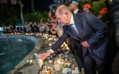 Bundeskanzler Olaf Scholz (SPD) steht bei seinem Solidaritätsbesuch in Israel mit einer Kerze am Dizengoff Square im Zentrum von Tel Aviv. - Foto: Michael Kappeler/dpa Pool/dpa