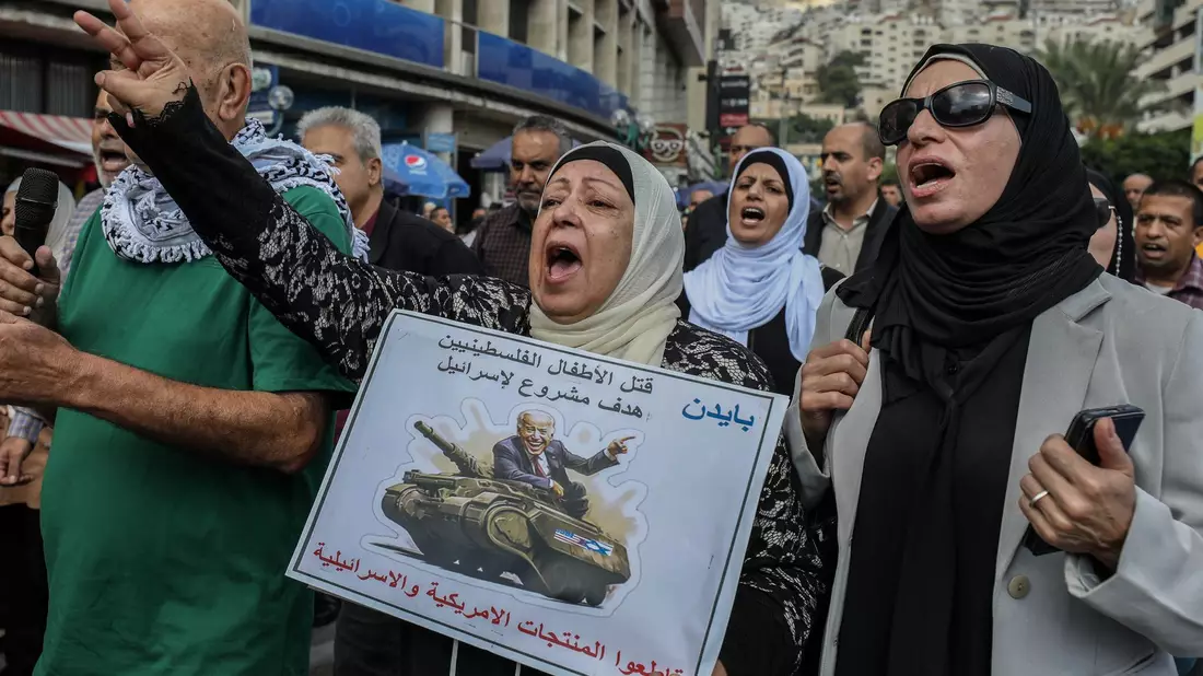 «Die Tötung palästinensischer Kinder ist ein legitimes Ziel für Israel» und «Boykottiert amerikanische und israelische Produkte», steht auf dem Schild dieser Demonstrantin in Nablus im Westjordanland. - Bild: Ayman Nobani/dpa