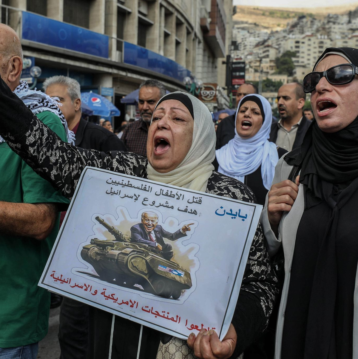 «Die Tötung palästinensischer Kinder ist ein legitimes Ziel für Israel» und «Boykottiert amerikanische und israelische Produkte», steht auf dem Schild dieser Demonstrantin in Nablus im Westjordanland. - Foto: Ayman Nobani/dpa