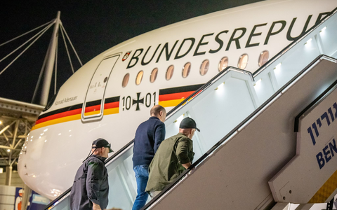 Bodyguards bringen Bundeskanzler Olaf Scholz nach dem Luftalarm in den Regierungs-Airbus. - Foto: Michael Kappeler/dpa Pool/dpa Bodyguards bringen Bundeskanzler Olaf Scholz nach dem Luftalarm in den Regierungs-Airbus. - Foto: Michael Kappeler/dpa Pool/dpa