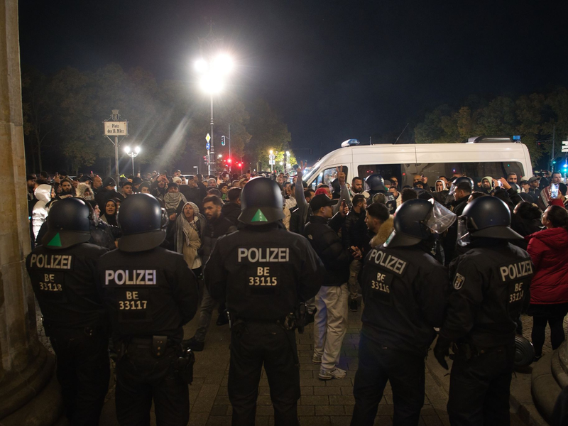 Palästinenser sowie deren Unterstützer streiten sich mit der Polizei vor dem Brandenburger Tor. - Foto: Paul Zinken/dpa