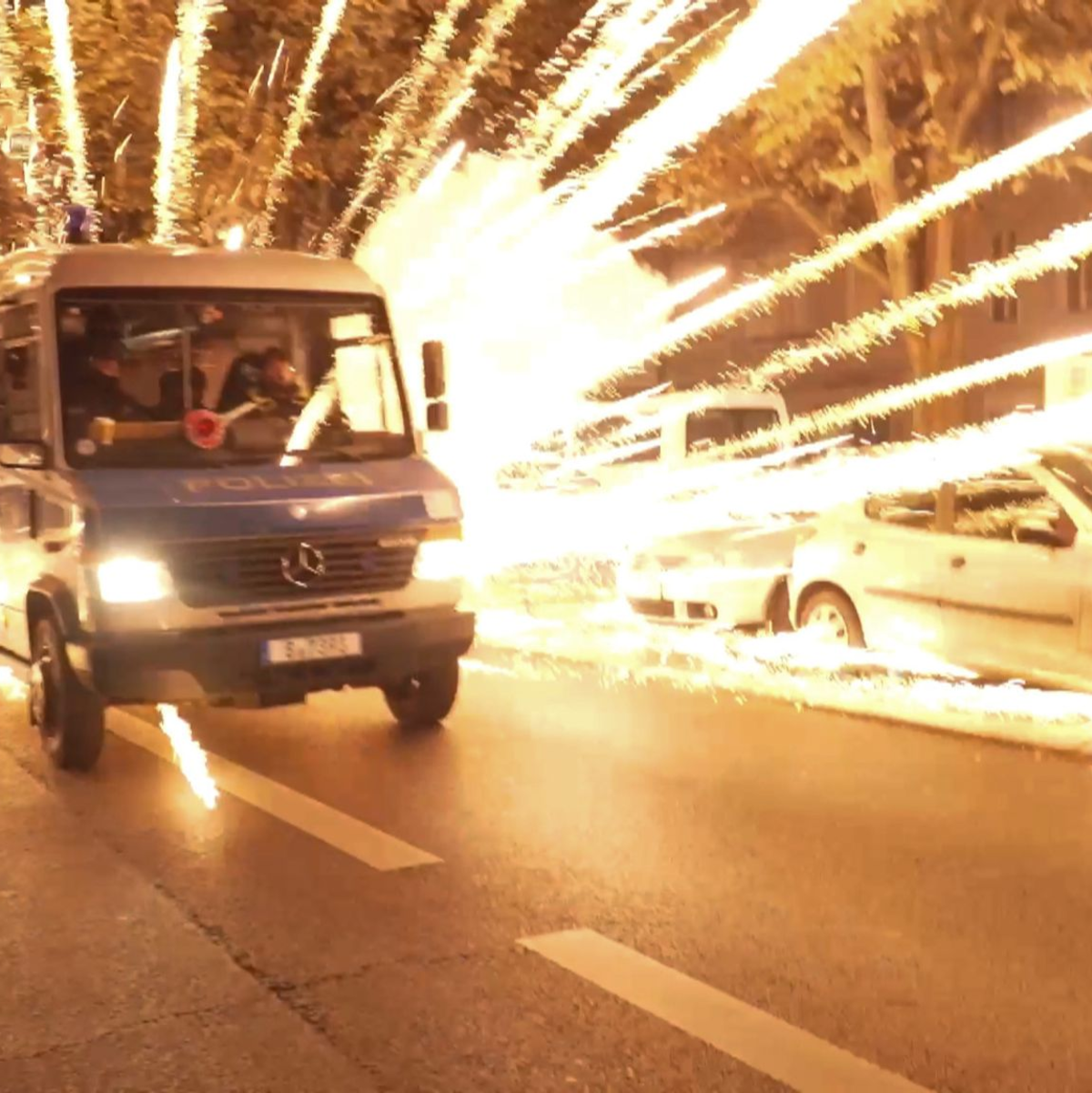 Feuerwerkskörper fliegen hinter einem Polizeiauto bei einer nicht angekündigten pro-palästinensischen Demonstration in Neukölln. - Foto: -/TNN/dpa