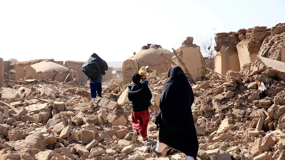 Menschen laufen über die Trümmer nach einem starken Erdbeben in der Provinz Herat im Westen Afghanistans. - Bild: Uncredited/Save the Children/AP/dpa