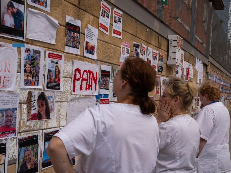Fotos der im Gazastreifen vermissten Menschen an einer Wand in Tel Aviv. Nachdem die Hamas am 7. Oktober Israel überfiel, fordern Angehörige und ihre Unterstützer die Rückkehr der Geiseln. - Foto: Petros Giannakouris/AP/dpa