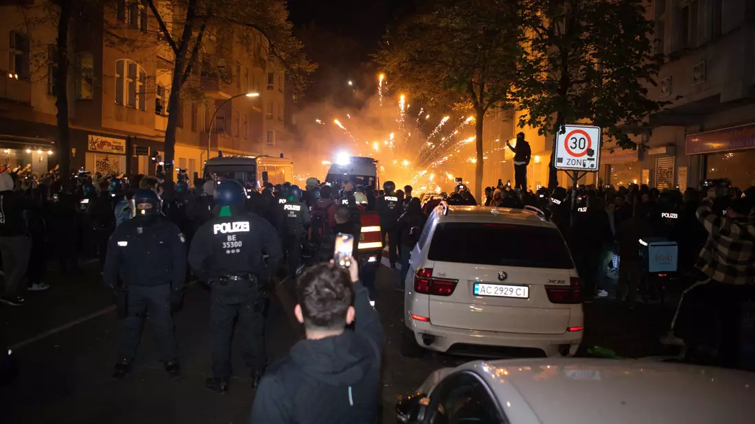 Teilnehmer einer verbotenen pro-palästinensischen Kundgebung in Berlin-Neukölln zünden Pyrotechnik. - Bild: Paul Zinken/dpa