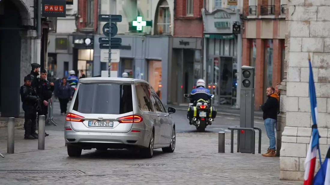 Der Leichenwagen mit dem Sarg des getöteten französischen Lehrers folgt einer Polizeieskorte. - Bild: Michel Spingler/AP /dpa