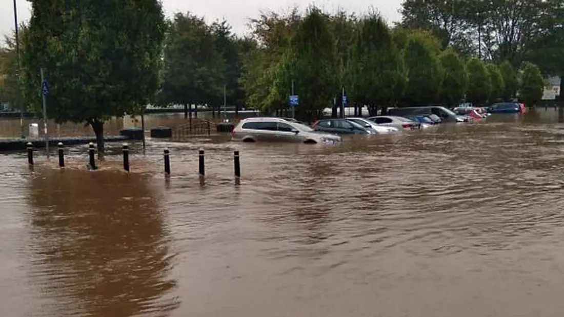 Autos in Kork stehen halb unter Wasser. - Bild: Maria Kring/PA Media/dpa