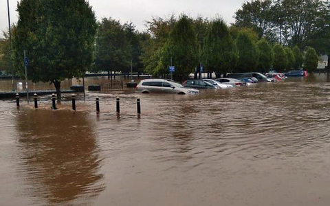 Autos in Kork stehen halb unter Wasser. - Foto: Maria Kring/PA Media/dpa