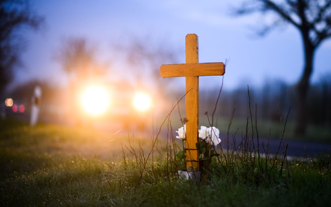 Ein Kreuz und Blumen zum Gedenken an ein 21-jähriges Opfer eines Verkehrsunfalls im Landkreis Hildesheim. - Foto: Julian Stratenschulte/dpa