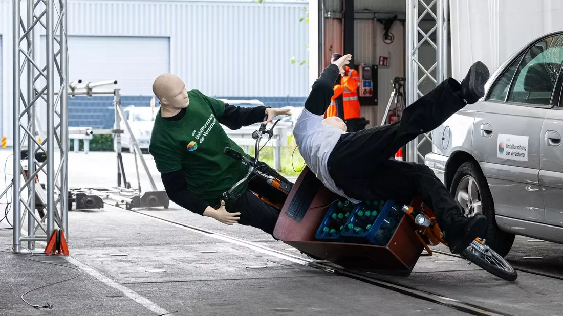 Bei einem Crashtest stoßen ein Lastenfahrrad und ein Fußgänger zusammen. - Bild: Guido Kirchner/dpa