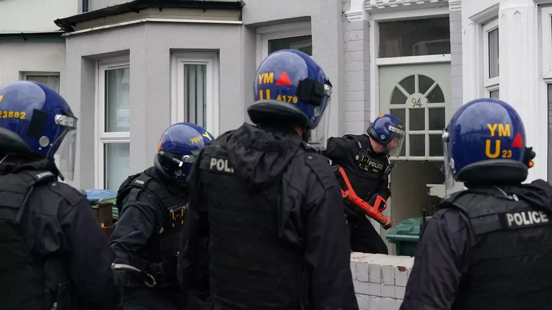 Beamte der Polizei der West Midlands verschaffen sich Zutritt zu einem Grundstück in Coventry. - Bild: Joe Giddens/PA Wire/dpa