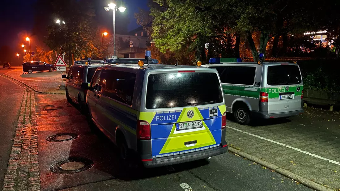 Polizeifahrzeuge stehen vor der Gesamtschule in Hollfeld im Landkreis Bayreuth. - Bild: Fricke/NEWS5/dpa