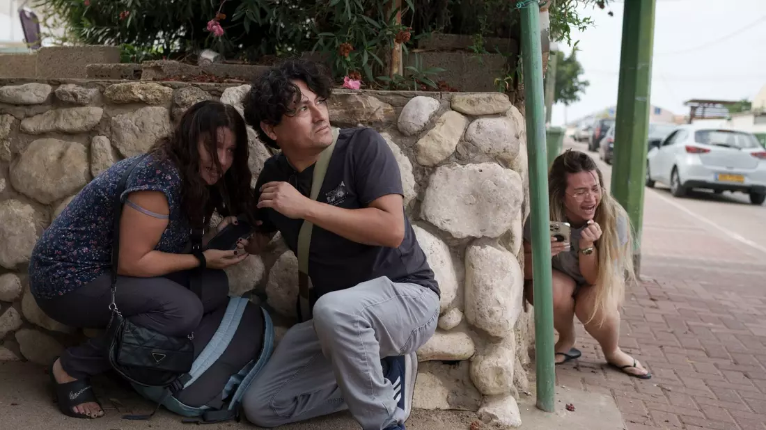 Menschen gehen im südisraelischen Aschkelon vor Raketenbeschuss aus dem Gazastreifen in Deckung. - Bild: Leo Correa/AP/dpa