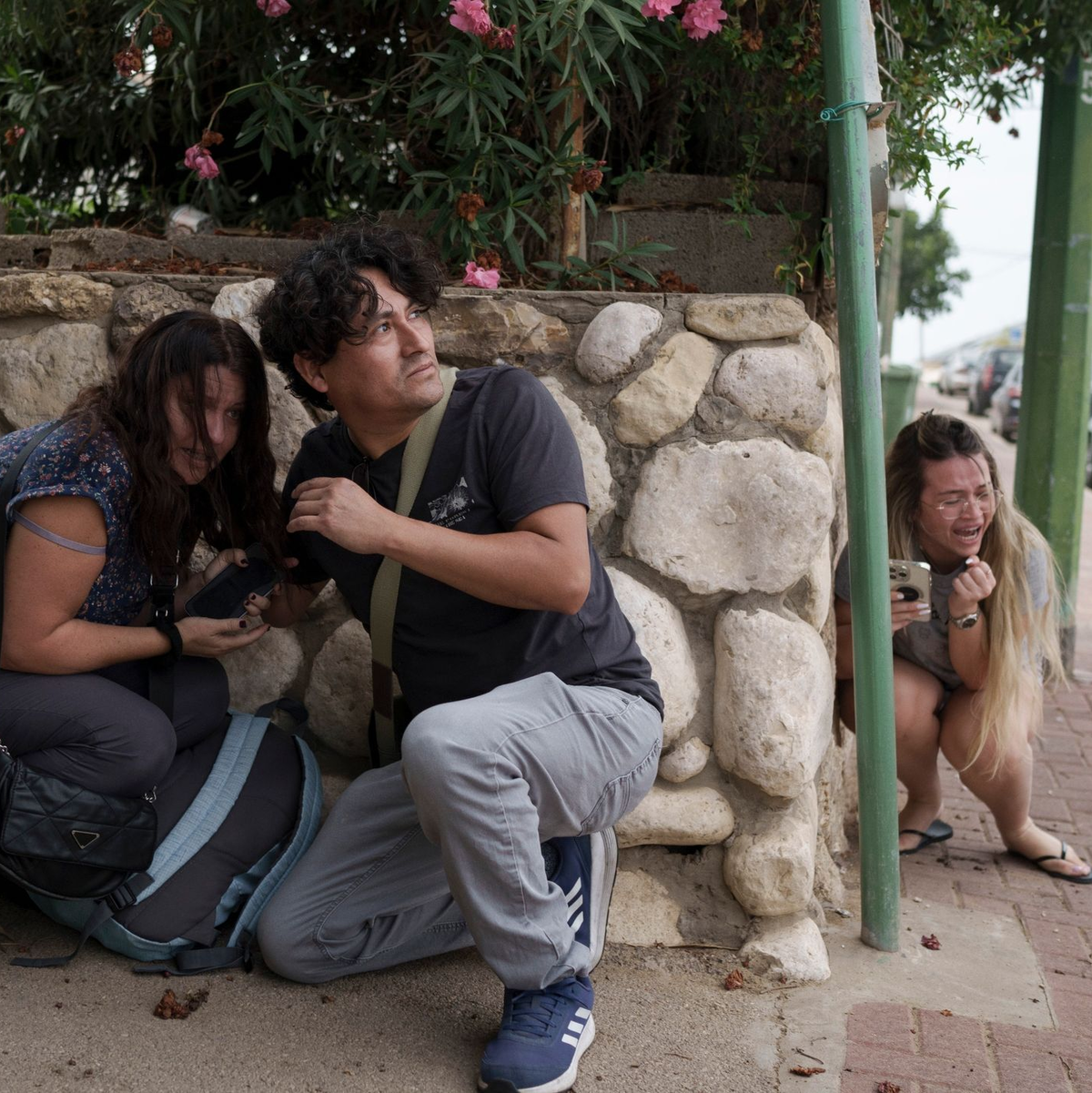 Menschen gehen im südisraelischen Aschkelon vor Raketenbeschuss aus dem Gazastreifen in Deckung. - Foto: Leo Correa/AP/dpa