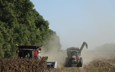 Ein Mähdrescher und ein Traktor der deutschen Agrarfirma UIFK Agro in der Ukraine bei der Sonnenblumenernte. - Foto: Friedemann Kohler/dpa