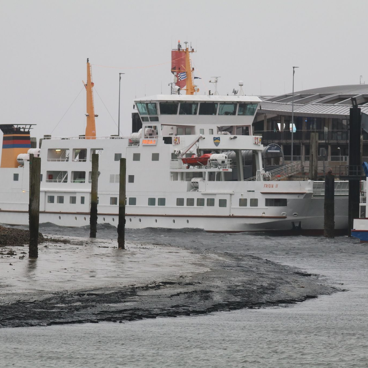 Eine Fähre liegt bei Niedrigwasser im Hafenbecken der Insel Norderney. - Foto: Volker Bartels/dpa