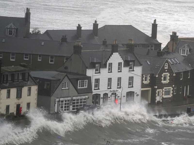 Hohe Wellen brechen an einer Kaimauer an der schottischen Nordseeküste. - Foto: Andrew Milligan/PA Wire/dpa