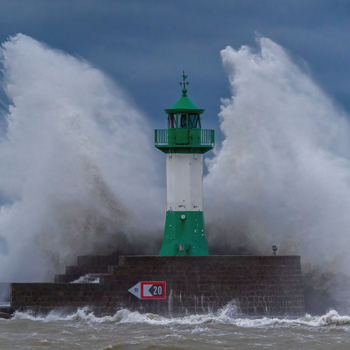 Wellen der Ostsee peitschen bei einem schweren Sturmtief an den Leuchtturm auf der Ostmole. Wegen des Sturmtiefs sind an der Ostseeküste Straßen und Uferbereiche vom Hochwasser überschwemmt worden. - Foto: Georg Moritz/dpa
