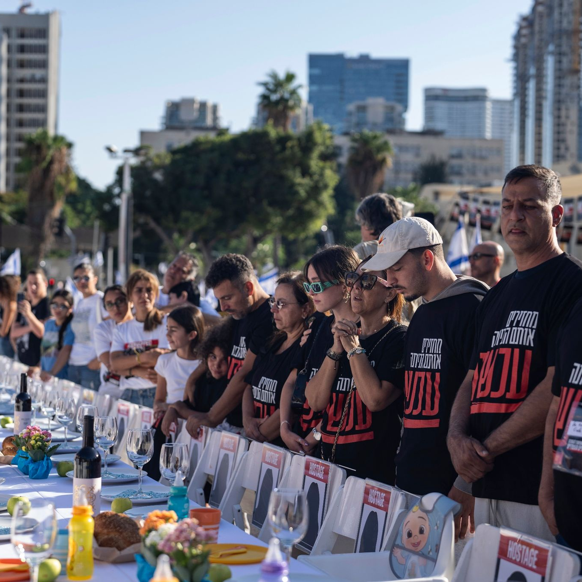 Angehörige von Menschen, die von Hamas-Kämpfern entführt wurden, beten in Tel Aviv umgeben von 203 leeren Stühlen. - Foto: Petros Giannakouris/AP/dpa