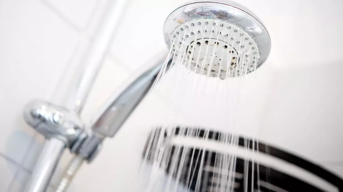 Ein Duschkopf hängt in einer Dusche in einem Badezimmer. - Bild: Hauke-Christian Dittrich/dpa