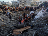 Palästinenser versammeln sich vor den Überresten eines zerstörten Hauses in Gaza-Stadt. - Foto: Abed Khaled/AP/dpa