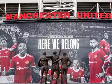 Vor dem Stadion Old Trafford stehen Statuen der ehemaligen Manchester-United-Spieler George Best, Denis Law und Sir Bobby Charlton. - Foto: Martin Rickett/PA Wire/dpa
