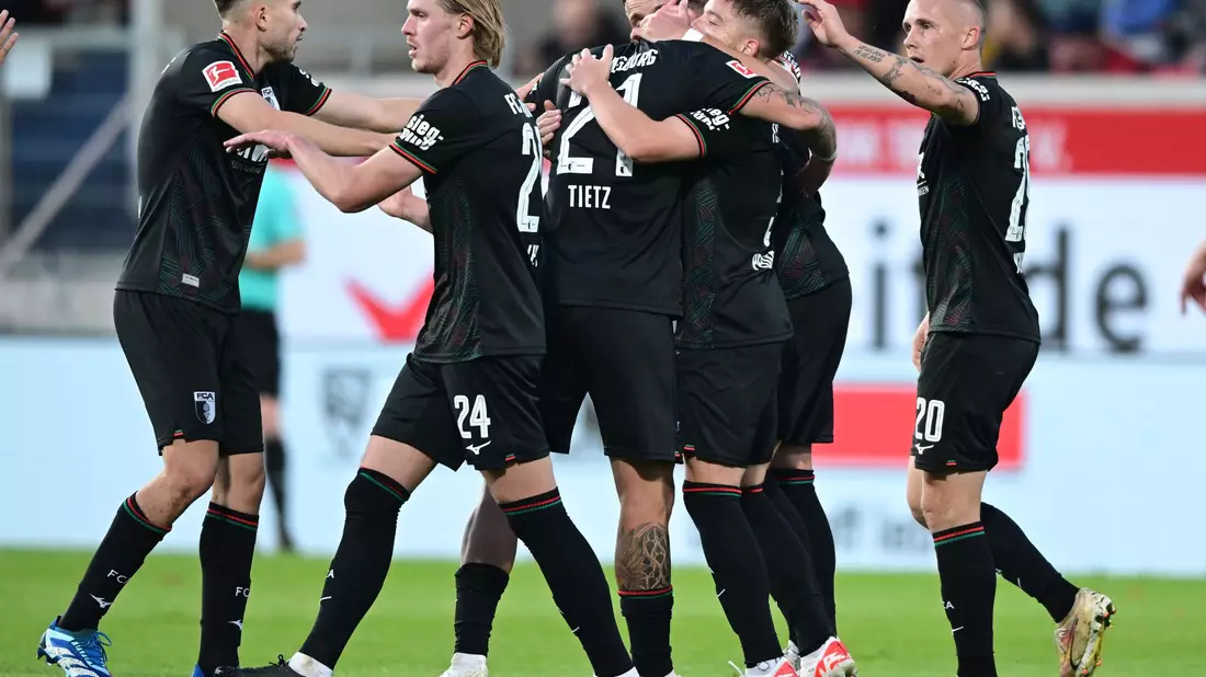 Augsburgs Spieler freuen sich über ein Tor bei Sieg in Heidenheim. - Bild: Bernd Weißbrod/dpa
