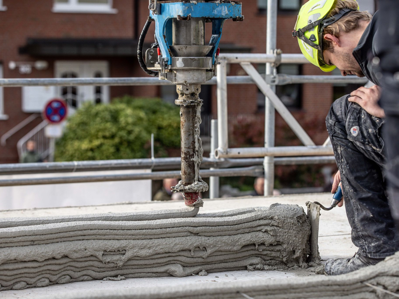 Ein Arbeiter inspiziert die Baustelle eines Mehrfamilienhauses aus dem 3D-Drucker. - Foto: Dieter Menne/dpa