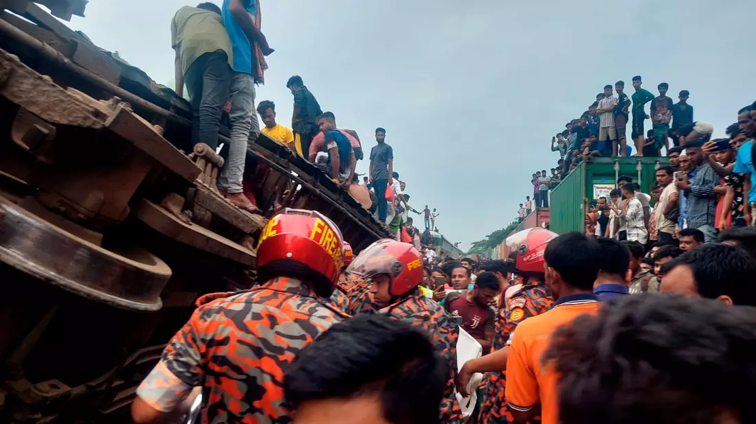 Rettungskräfte nach dem Zusammenstoß eines Güterzuges mit einem Personenzug in Bangladesch. - Bild: -/Bangladesh Fire Service and Civil Defense Department/AP/dpa
