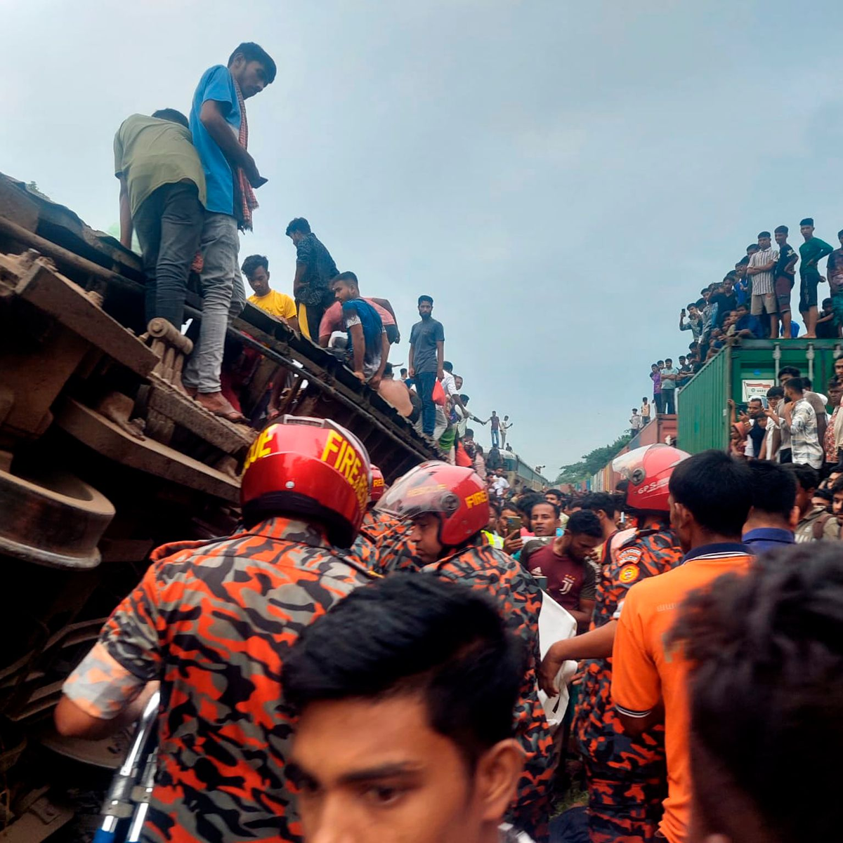 Rettungskräfte nach dem Zusammenstoß eines Güterzuges mit einem Personenzug in Bangladesch. - Foto: -/Bangladesh Fire Service and Civil Defense Department/AP/dpa